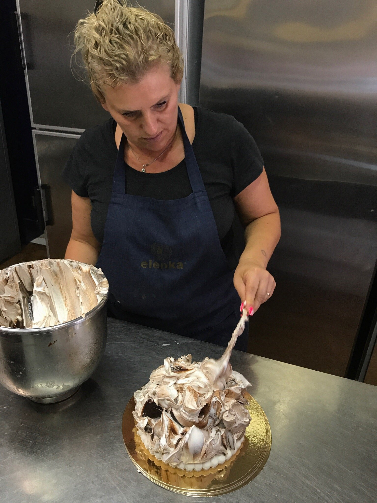 La nostra pasticcera decora a mano una torta gelato nel laboratorio di Gelateria Splash